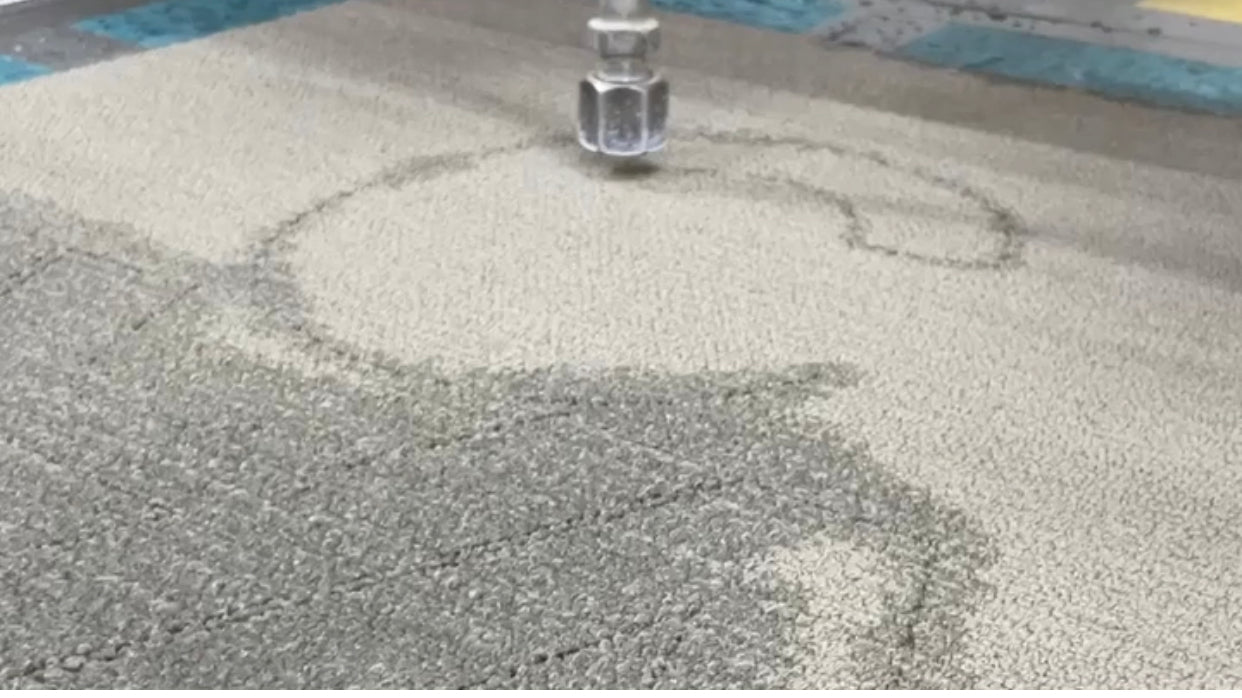 Load video: Waterjet cutting carpet into letters for carpet signage at a cinema.